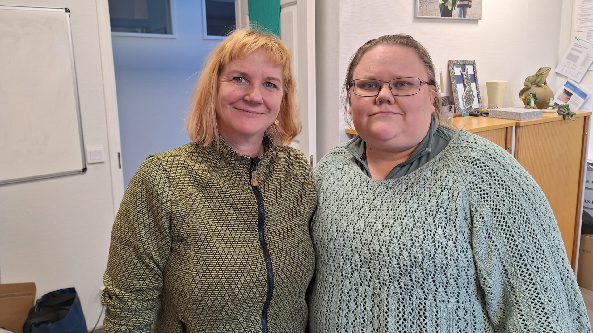 Kaksi henkilöä seisoo vierekkäin hymyillen.