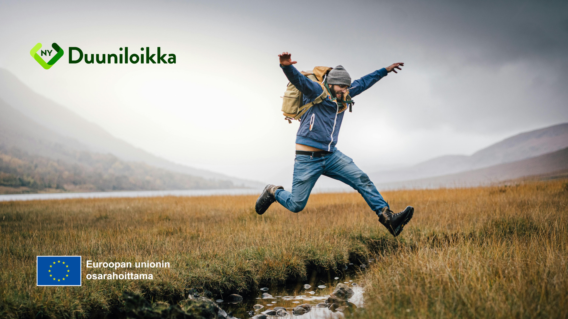Mies loikkaa suopuron yli syksyisessä maisemassa.