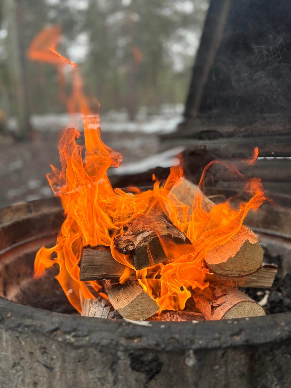 Lähikuva nuotiosta, jossa roihuavat liekit.